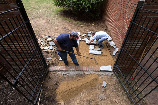 Agustin Delgado (left) and Dwayne Mclaurin create new courtyard paths and decorative areas at Parker Residence Hall.