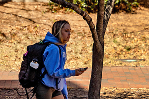 Student walking while holding phone