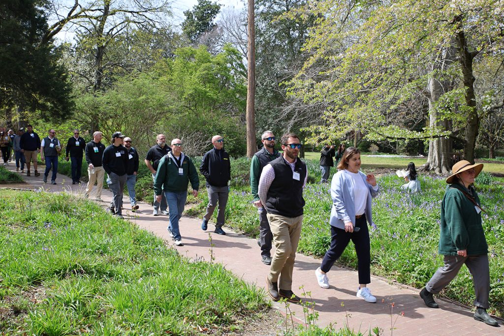 the tour group walking through Coker Arboretum